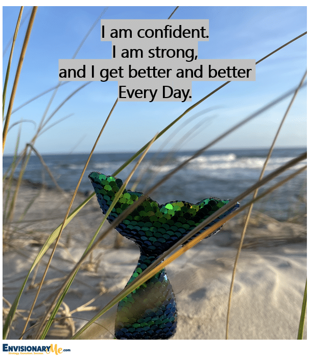 Image of glass fish on the sand by the ocean with the quote, "I am confident. I am strong, and I get better and better Every Day