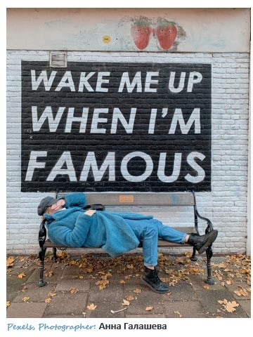 Wake me up when I'm famous. Man resting on bench image