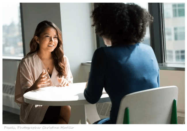Women mentors sitting at table having a discussion with each other