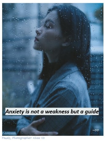 Business women image standing in rain. Text added "Anxiety us not a weakness but a guide."